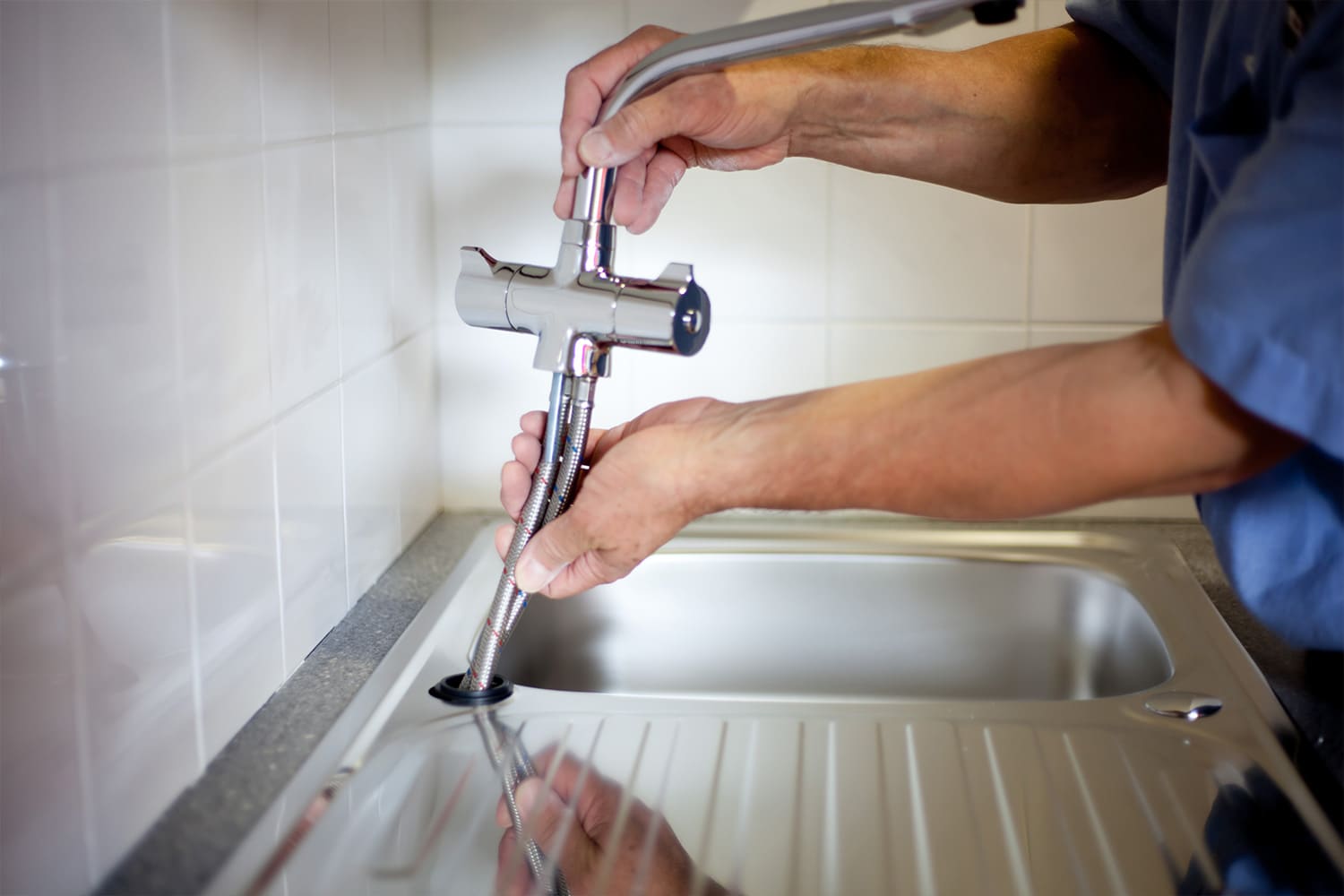 homme qui change un robinet de cuisine